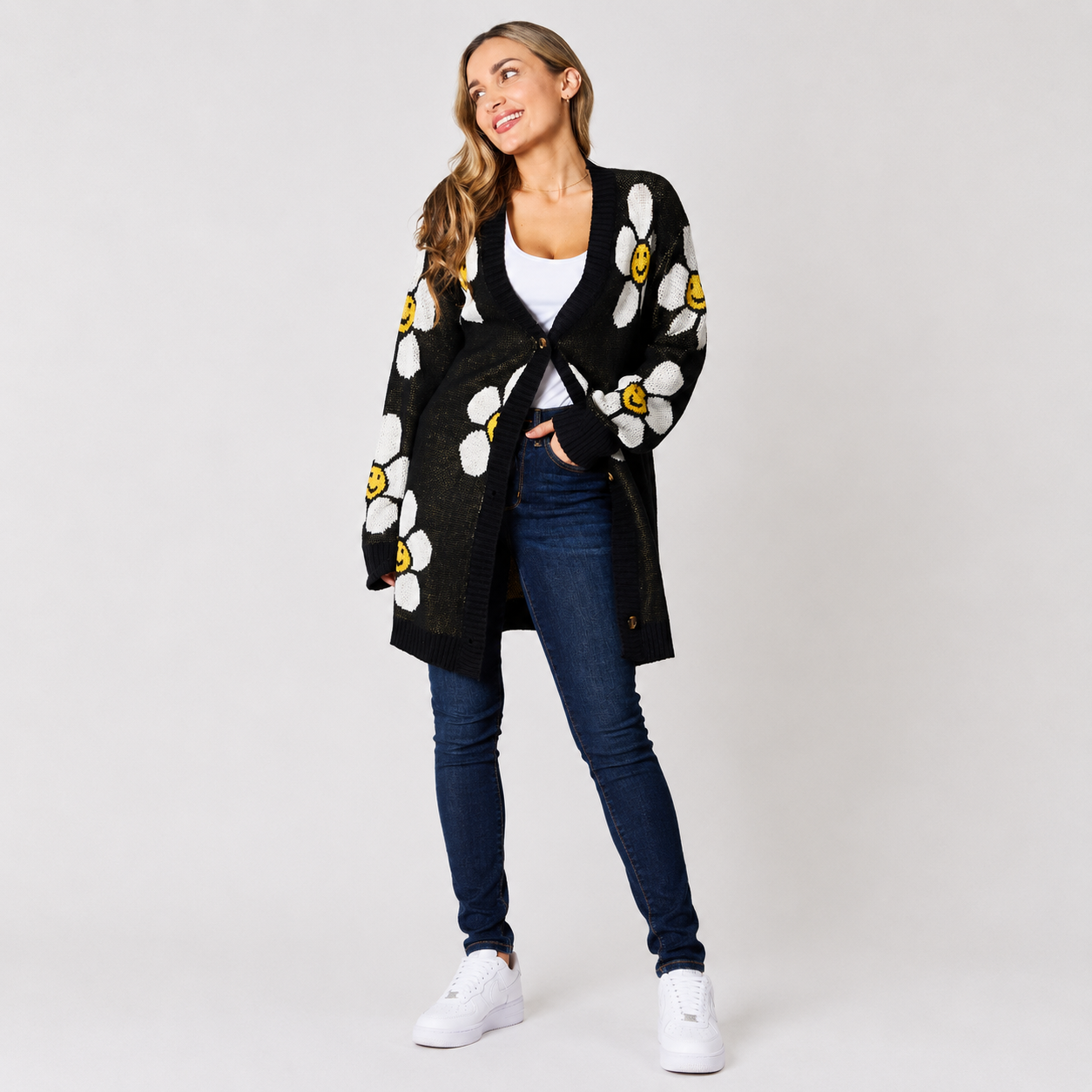 Woman wearing a black floral button-down cardigan with daisy pattern