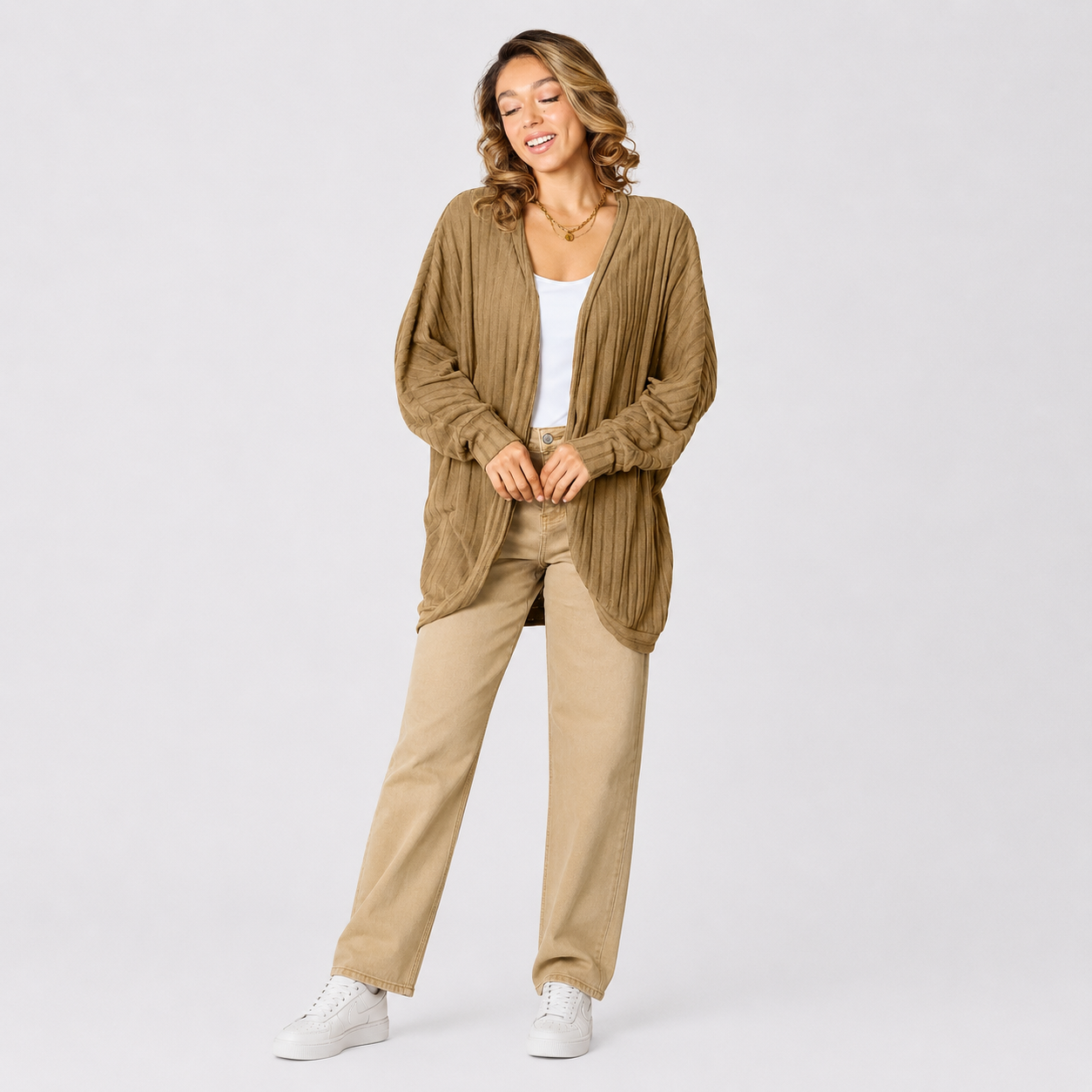 Women's black ribbed cardigan sweater styled with beige pants