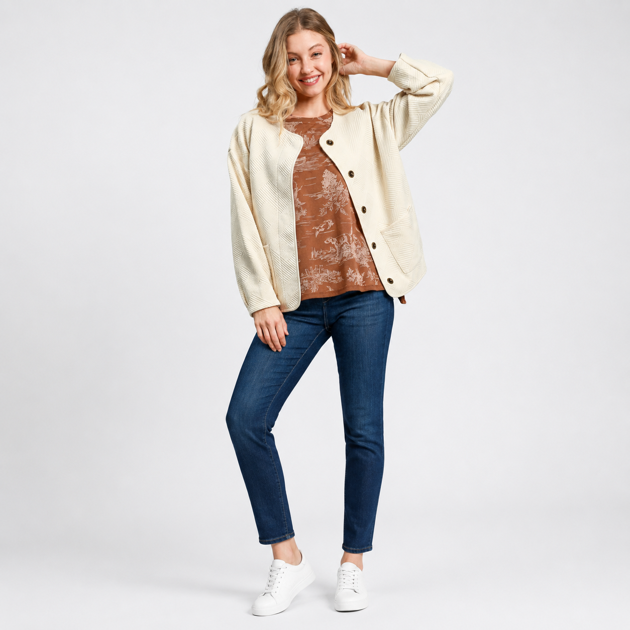 Woman wearing a cream textured jacquard jacket with button front closure